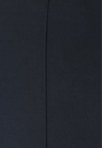 Tissu extensible bleu marine avec une texture lisse, présentant une couture centrale verticale, idéal pour la conception de vêtements ajustés.