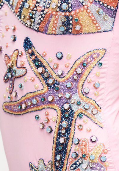 Tissu rose décoré d'étoiles de mer colorées en perles et strass, ainsi que de petites perles dispersées.