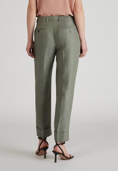 Zielone lniane spodnie o prostym kroju, z podwiniętymi mankietami i dwiema tylnymi kieszeniami zapinanymi na guziki. Wykończenie satynowe.