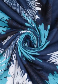 Tessuto multicolore con un design a spirale nei toni del blu navy, turchese e bianco. La texture appare morbida e leggera.