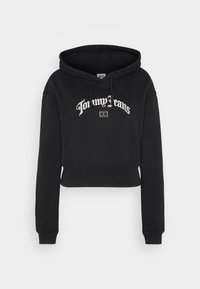 Czarna krótka bluza z kapturem z poprawką, z białym haftem z napisem "Dla moich dżinsów" oraz akcentem logo poniżej tekstu.