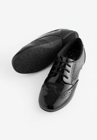 Schwarze Lackleder-Schnürschuhe mit Broguedetails, runder Zehenform und strukturierten floral-musterbezogenen Außensohlen. Glatte, glänzende Oberfläche.