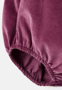 Fialový velúrový materiál s hladkým povrchom a naťahovacou elastickou páskou okolo lemu, ktorý predvádza jemnú, bohatú farbu a nadýchaný vzhľad.