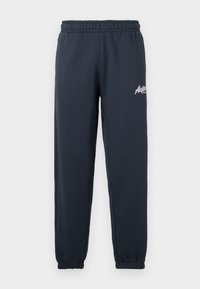 Mørkegrå joggebukser med elastisk midje, innsvingte ben og en hvit logo trykt på venstre lår. Myk bomullsblanding.
