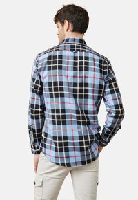 Camisa de manga corta a cuadros con un patrón de cuadros azul, negro y rojo, cuello tipo botón y dobladillo recto, confeccionada en una tela ligera.