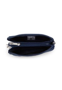 Kipling zippered wallet in dark blue fabric with textured accents, featuring an interior compartment and a logo label. Zipper hardware visible.