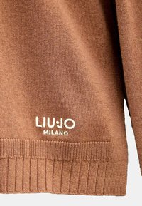 Maglione a maglia marrone con orlo e polsini a coste. Logo ricamato "LIU:JO MILANO" in bianco nell'angolo in basso a sinistra. Texture morbida.
