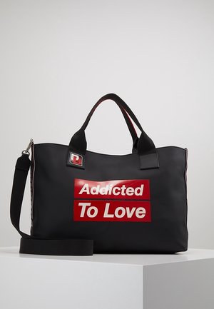 Czarna torba na ramię z czerwonym napisem "Uzależniona od miłości", wykonana z gładkiego materiału, z dwoma uchwytami i odpinanym paskiem na ramię.