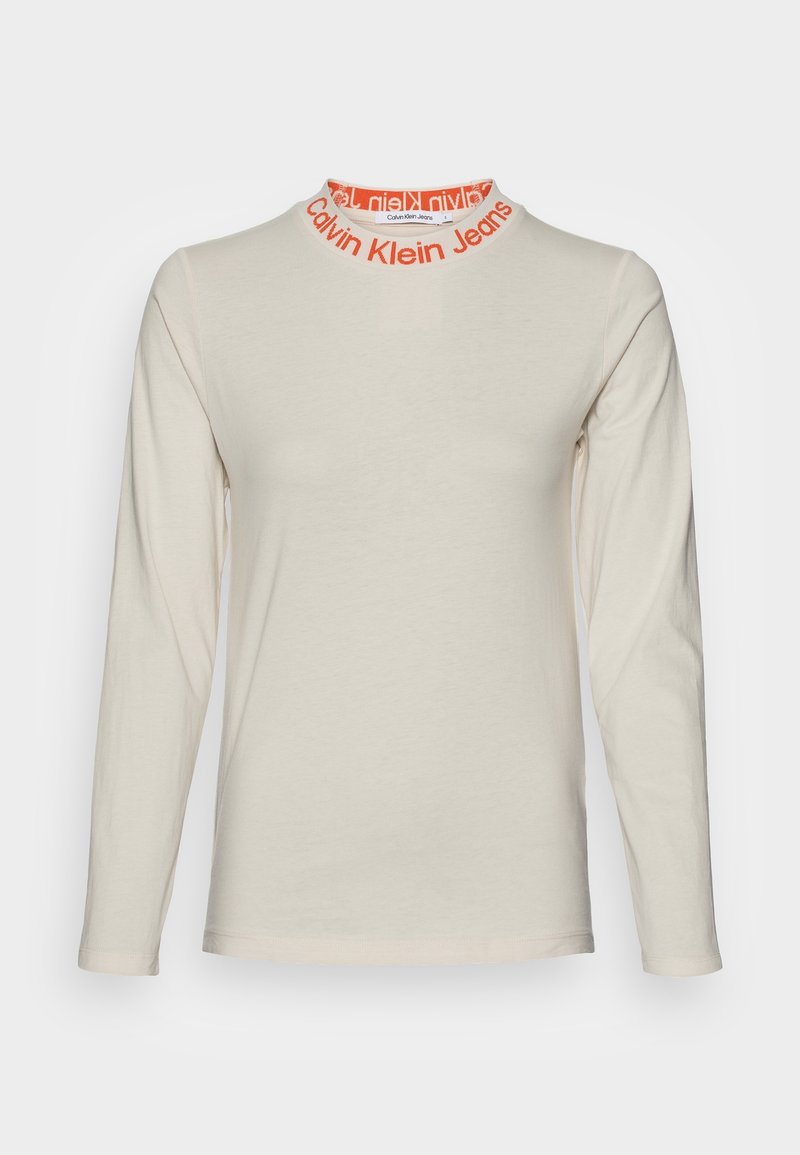 Béžová košile s dlouhým rukávem a kulatým výstřihem, která má kolem límce oranžový nápis "Calvin Klein Jeans", hladký přední díl a slim fit.