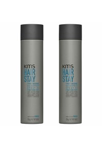 Zwei zylindrische graue Haarsprayflaschen mit schwarzen Kappen. Die Etiketten zeigen blauen Text, der "KMS Hair Stay" hervorhebt, sowie Produktdetails in mehreren Sprachen.