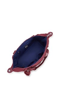 Borsa bordeaux con chiusura a zip, dotata di un interno blu e un charm peloso. L'interno presenta tasche e un'etichetta visibile.