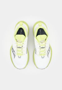 Witte sportschoenen met gele accenten, een getextureerde mesh bovenkant en gevoerde zolen. Voorzien van ogen, veters en een logo aan de zijkant.