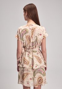 Beiges Kurzarmkleid mit einem blumigen Paisleymuster. Verfügt über Rüschendetails, eine taillierte Taille und einen leichten, strukturierten Stoff.