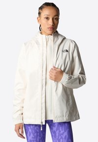 Valkoinen, kevyt, vetoketjullinen takki hupulla, jossa on elastiset hihansuut ja The North Face -logo; sileä pinta, rento muotoilu.