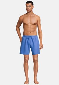 Siniset uima-shortsit, joissa on joustava vyötärö ja säätönyöri. Shortsien pinta on sileä ja niissä on pieni valkoinen logo alhaalla edessä.