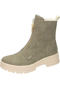 Bottine en simili cuir kaki avec fermeture éclair dorée, doublure crème et semelle en caoutchouc beige texturée. Présente des accents brodés et un logo.