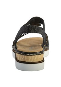 Sandali con cinturini glitterati neri e suola in gomma bianca, dotati di un footbed simile sughero e cuciture decorative. Design aperto sul retro per una facile calzata.