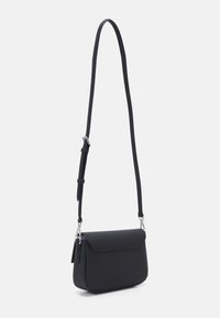 Sac en bandoulière noir en matériau lisse avec une fermeture à rabat, une bandoulière ajustable et des fournitures en métal argenté. Design compact et rectangulaire.