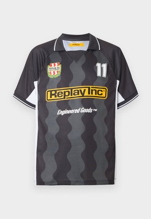 Čierny a sivý vlnitý pruhovaný futbalový dres s krátkym rukávom, biele bočné panely, logo Replay Inc, číslo 11 a klubový erb na hrudi.