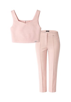 Top corto rosa cipria senza maniche con scollatura quadrata abbinato a pantaloni sartoriali coordinati a vita alta e lunghezza alla caviglia.
