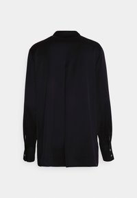 Maglietta a maniche lunghe di un blu navy scuro con colletto classico, tessuto morbido e polsini con bottoni, dotata di una piega centrale sul retro per un tocco di dettaglio.