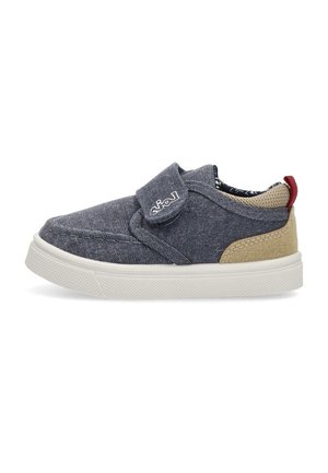 Zapato slip-on de denim en azul oscuro con acentos beige, correa de Velcro, suela texturizada y forro interior estampado.
