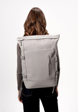 Grijze rolltop rugzak met verstelbare zijgespen, een voorvak met rits en een elegante, gladde stof. Eenvoudig, modern ontwerp.