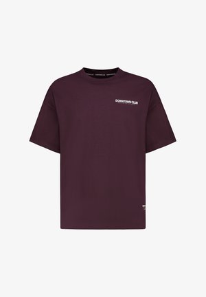 Burgundy cotton t-shirt with a crew neck, short sleeves, and white "DOWNTOWN CLUB" text on the left chest and lower hem detail.