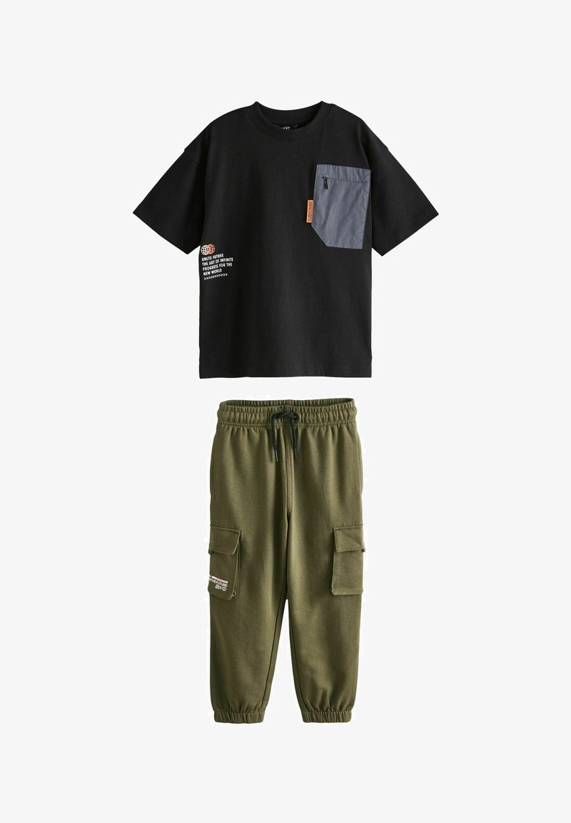 Sort bomulds T-shirt med en grå lomme og trykt tekst; olivengrønne sweatpants med elastiske manchetter og to sidelommer.
