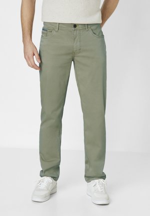 Light green chinos with a straight leg, featuring front pockets, a button closure, and subtle stitching details, paired with white sneakers.