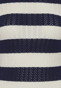 Top in maglia con ampie righe alternate blu navy e crema. Il tessuto presenta un motivo strutturato con piccoli dettagli a occhiello.