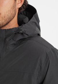Black waterproof jacket featuring a hood with adjustable drawstrings, smooth texture, and minimal stitching details.