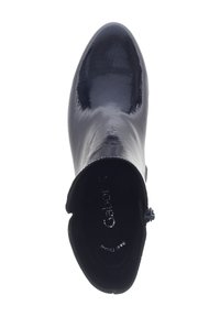 Chaussure en cuir verni noir avec un bout pointu, surface lisse et fermeture éclair à l'arrière. L'intérieur est doté d'une doublure douce.
