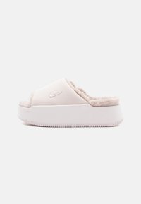 Sandalia tipo slide de Nike en rosa claro, con un forro de pelo suave, material superior liso y una suela blanca gruesa con un fondo texturizado.