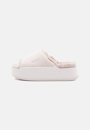 Nike-Sandale in Hellpink, mit einem weichen Fellfutter, glattem Obermaterial und einer dicken weißen Sohle mit strukturiertem Boden.