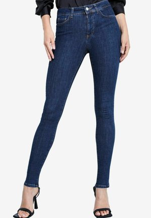 Jeans skinny in denim blu scuro, design a vita alta, con cinque tasche, dettagli di cucitura e una texture leggermente sbiadita.
