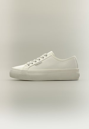 Basket blanche à lacets, avec une tige lisse et une semelle plateforme épaisse, présentée de profil sur un fond clair.