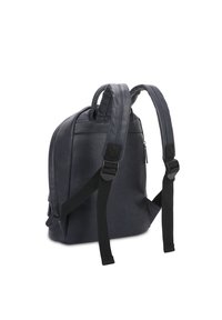 Zaino in pelle di un blu navy scuro, con spallacci imbottiti e una tasca con zip. Texture liscia, forma strutturata e dettagli di design minimalisti.