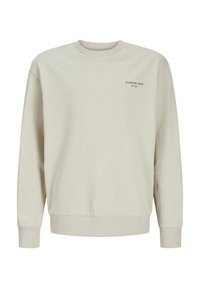 Ljust beige sweatshirt i mjuk bomullsblandning. Har ribbad hals och ärmslut, med svart textlogga på vänster bröstområde.