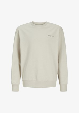 Light beige sweatshirt made of soft cotton blend. Features a ribbed neck and cuffs, with black text logo on the left chest area.