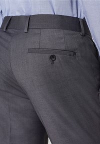 Pantaloni grigi su misura con una texture liscia, dotati di una tasca posteriore singola e chiusura con bottone. Vestibilità classica e dettaglio di piega appuntita.