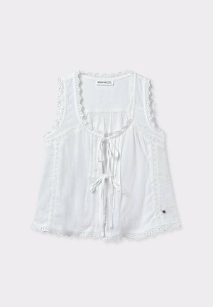 Top sin mangas de color blanco, confeccionado en una tela ligera, que presenta un lazo en la parte delantera, borde de encaje y diseño texturizado con acentos decorativos.
