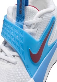 Baskets blanches avec une tige en mesh respirant, une sangle en plastique bleue, un logo Nike rouge et un talon bleu texturé. Elles disposent de lacets blancs.