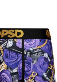 Daugiakampiai vyriški trumpikiai su juodu juosmeniu, kuriame užrašyta "PSD" auksine spalva. Dizainą sudaro violetinės rožės, dolerio banknotai, deimantai ir grandinėlės.