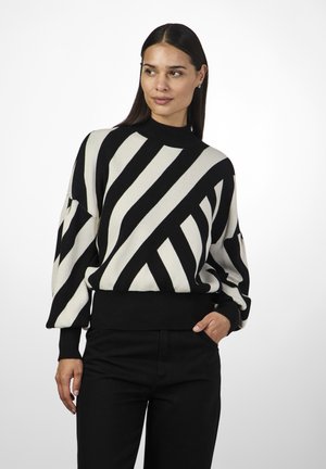 Pull rayé noir et blanc avec un col haut, coupe ample et ourlet côtelé. Le pull présente des lignes diagonales et de grandes manches.