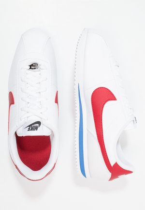 Hvide Nike sneakers med røde swoosh-logoer, snøredesign, rød indvendig foring og blå stribe på sålen, vist fra top- og sidevisninger.