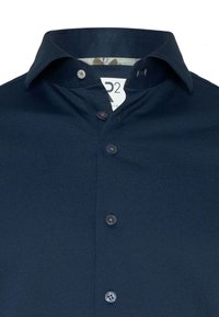 Marineblauw overhemd met knopen van textuurstof, met een patroon aan de binnenkant van de kraag en vijf bijpassende knopen aan de voorkant.