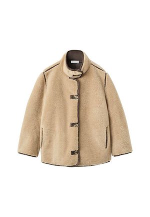 Chaqueta de piel de borrego beige con un alto cuello, cierre de botones, bolsillos frontales y costuras oscuras en contraste. Textura suave con un diseño relajado.