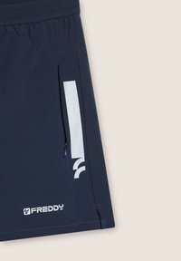 Shorts blu navy realizzati in un materiale leggero presentano un logo bianco e una tasca con zip laterale. Il design include una cintura elastica per il massimo comfort.
