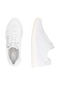 White sneakers with a smooth leather material, lace-up design, side zipper, and textured rubber sole with a beige accent.